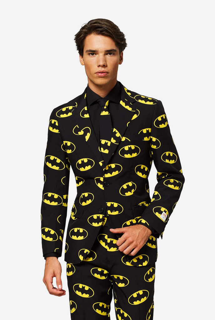 Man wearing Black suit with Yellow Batman logos.
