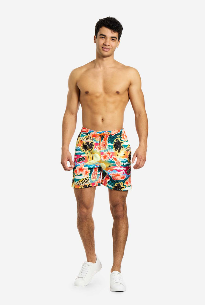 Man wearing swim trunks with tropical Hawaiian print