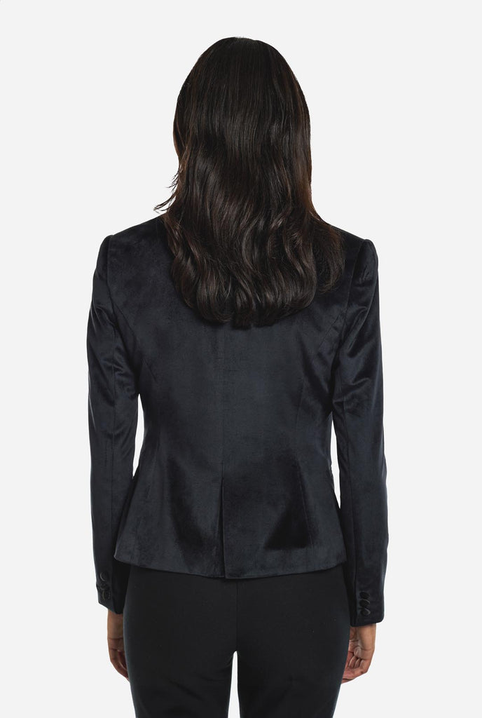 Woman wearing black velvet dinner jacket blazer, view from the back