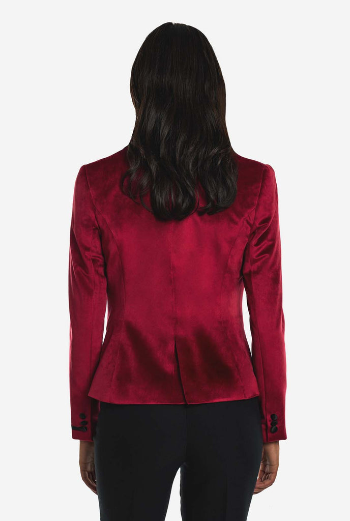 Woman wearing burgundy red velvet dinner jacket blazer, view from the back