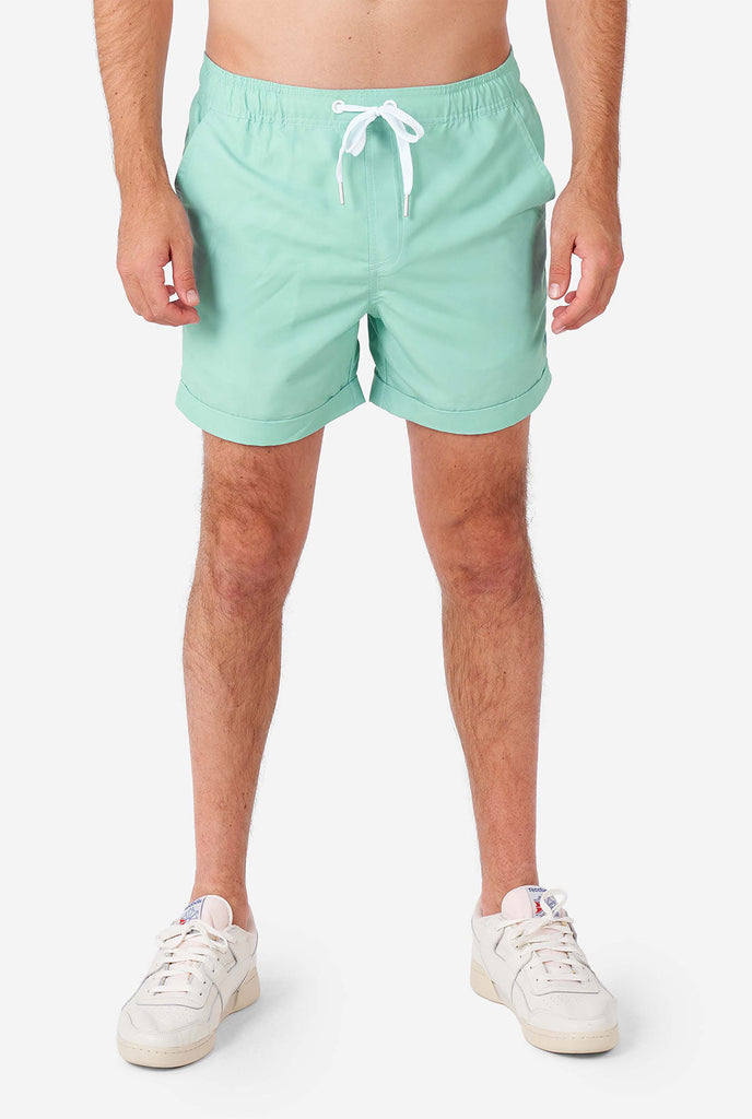 Man wearing green summer set, consisting of short sleeve shirt and shorts.