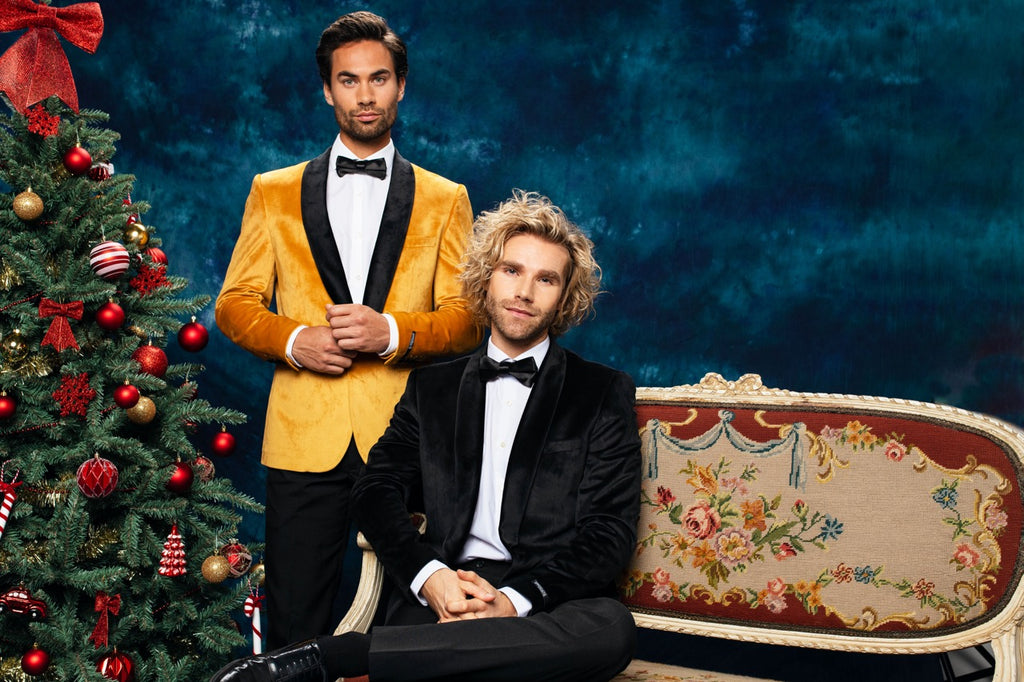 Men wearing Christmas dinner jacket next to Christmas tree