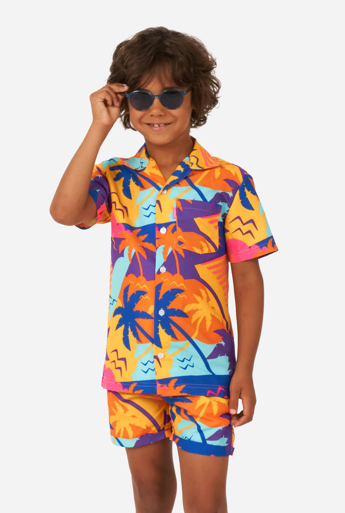 Boy wearing colorful palm summer set, consisting of shorts and shirt