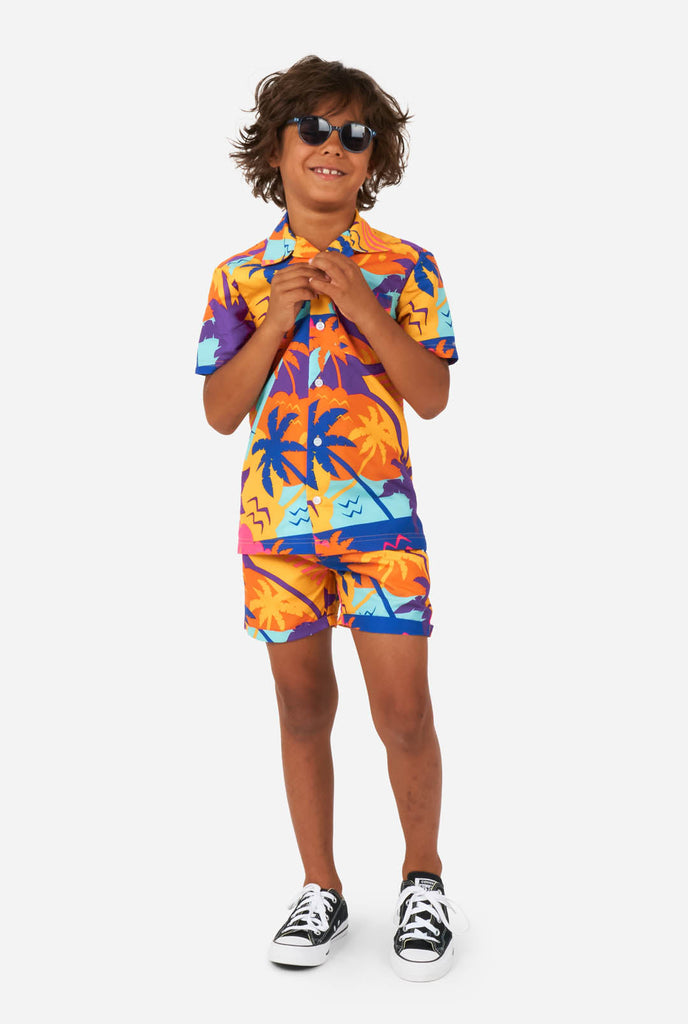 Boy wearing colorful palm summer set, consisting of shorts and shirt