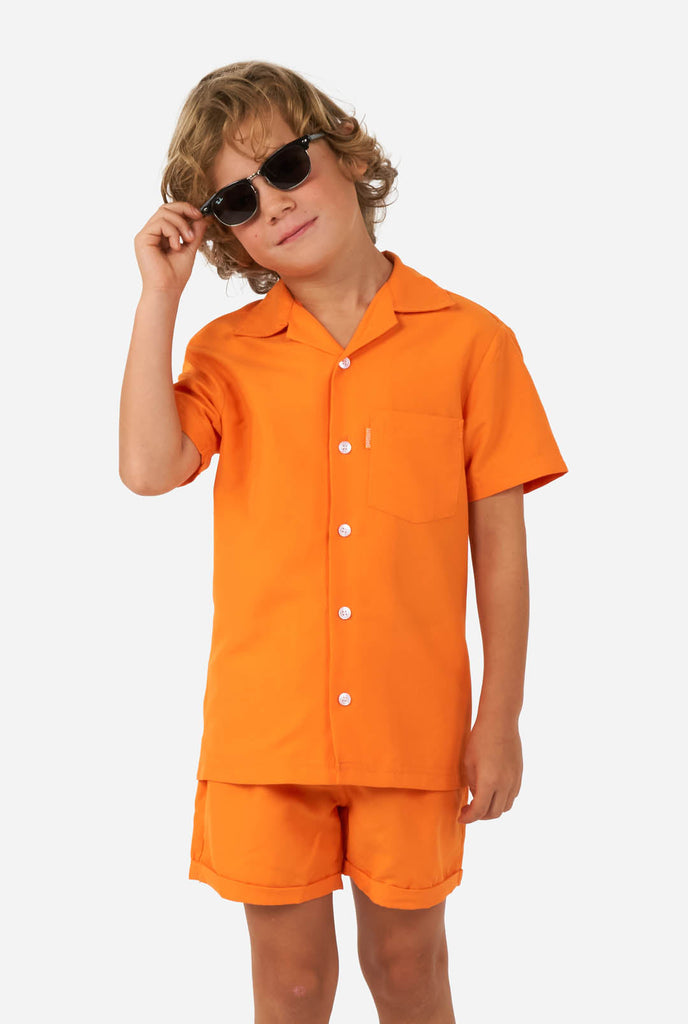 Boy wearing orange summer set, consisting of shorts and shirt 