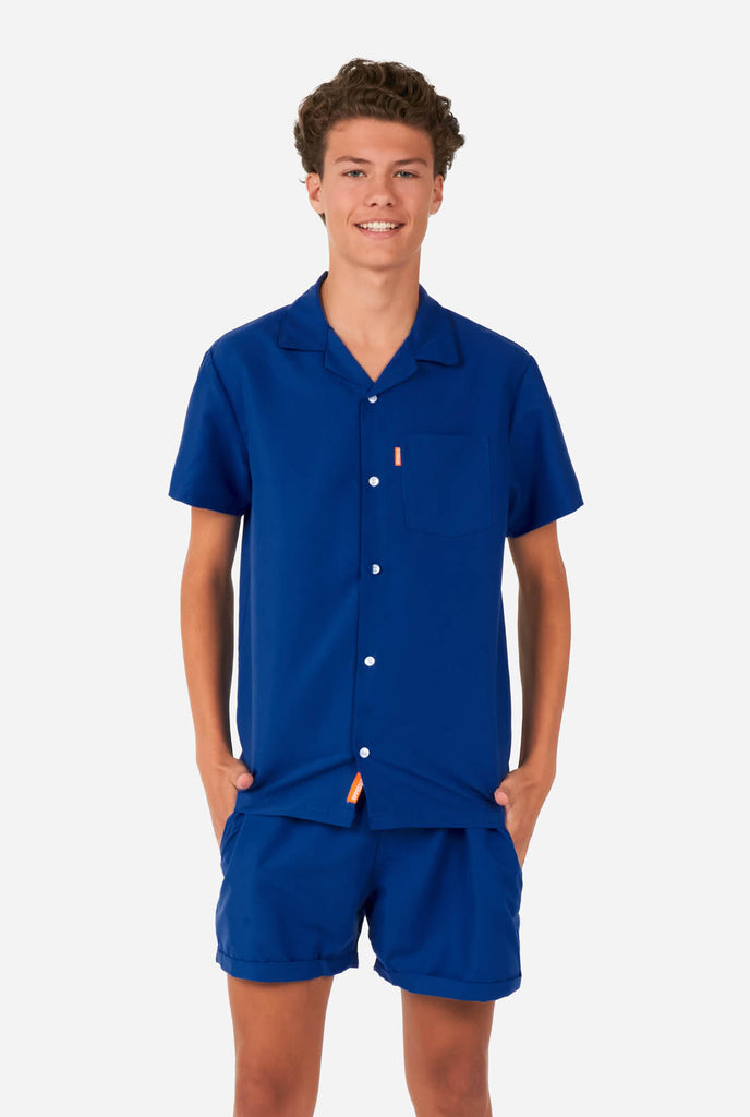 Teen wearing blue summer set, consisting of shirt and short.
