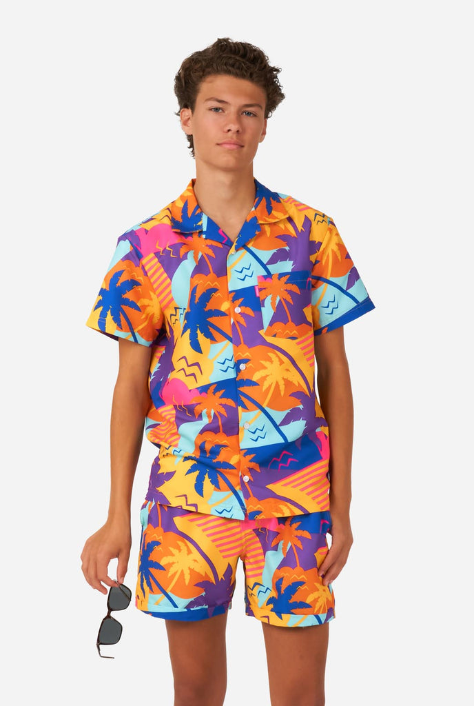 Teen wearing colorful palm summer set, consisting of shirt and short.
