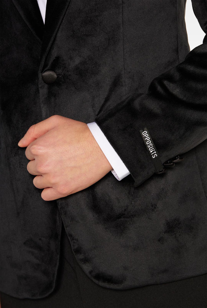 Teen wearing black velvet dinner jacket blazer for teen boys, close up.