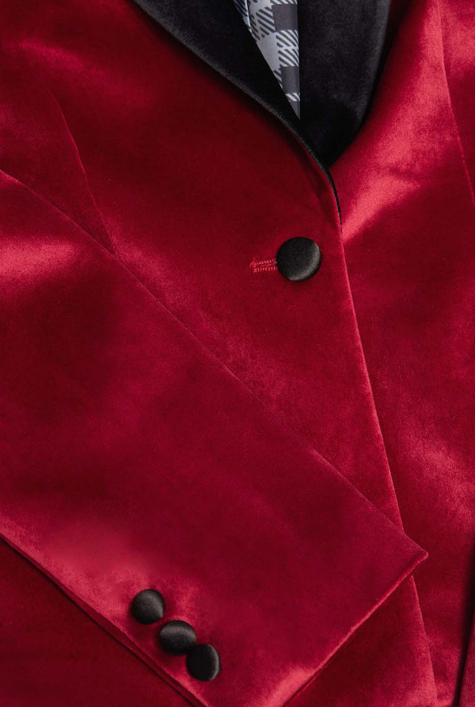 Woman wearing burgundy red velvet dinner jacket blazer, close up