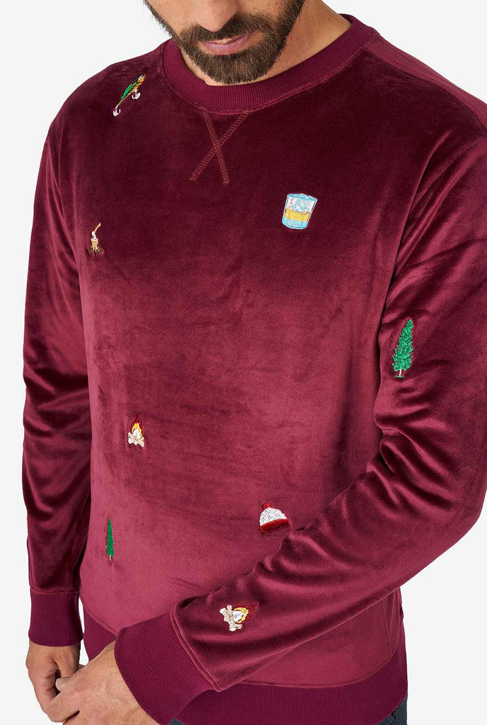 Man wearing velver burgundy red Christmas sweater with Christmas icons