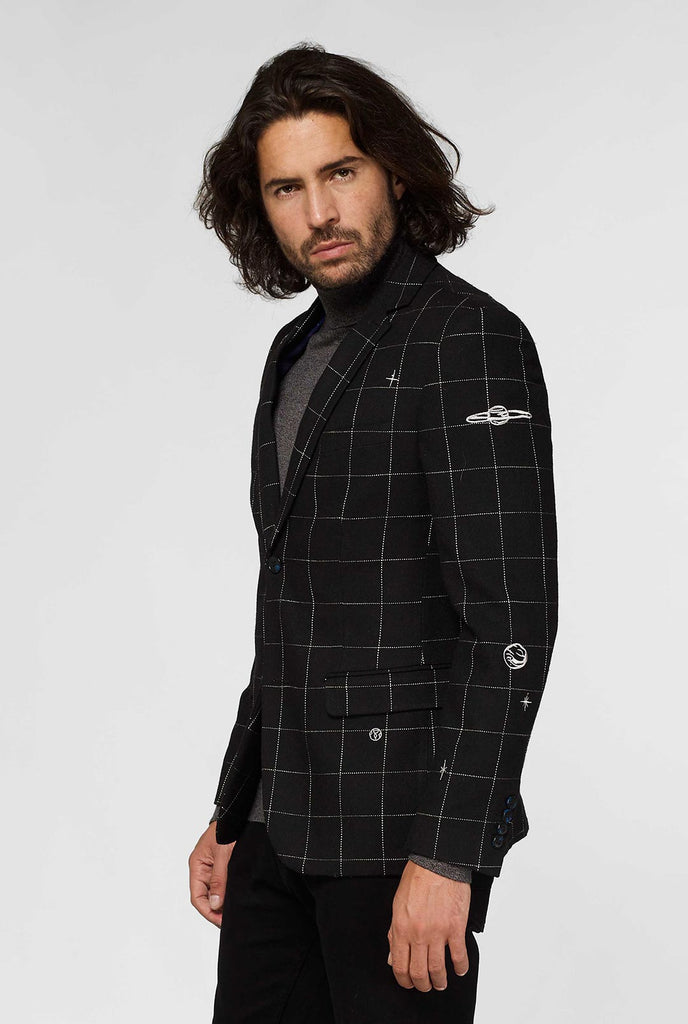 Black casual blazer with white grid pattern worn by man sitting on stool