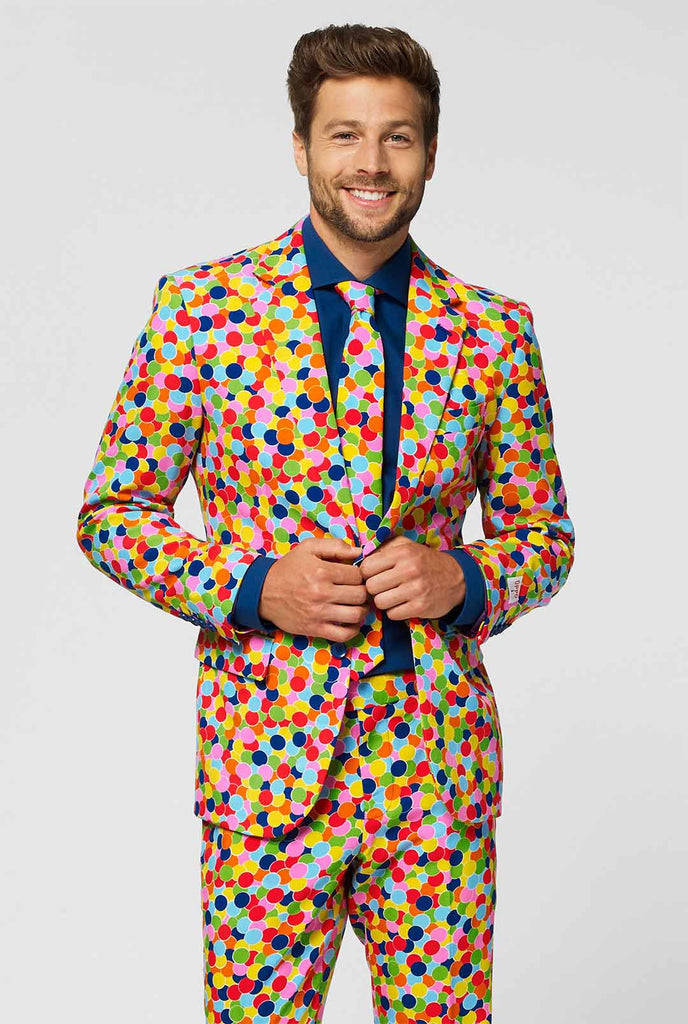 Man wearing men's suit with confetti print and blue dress shirt