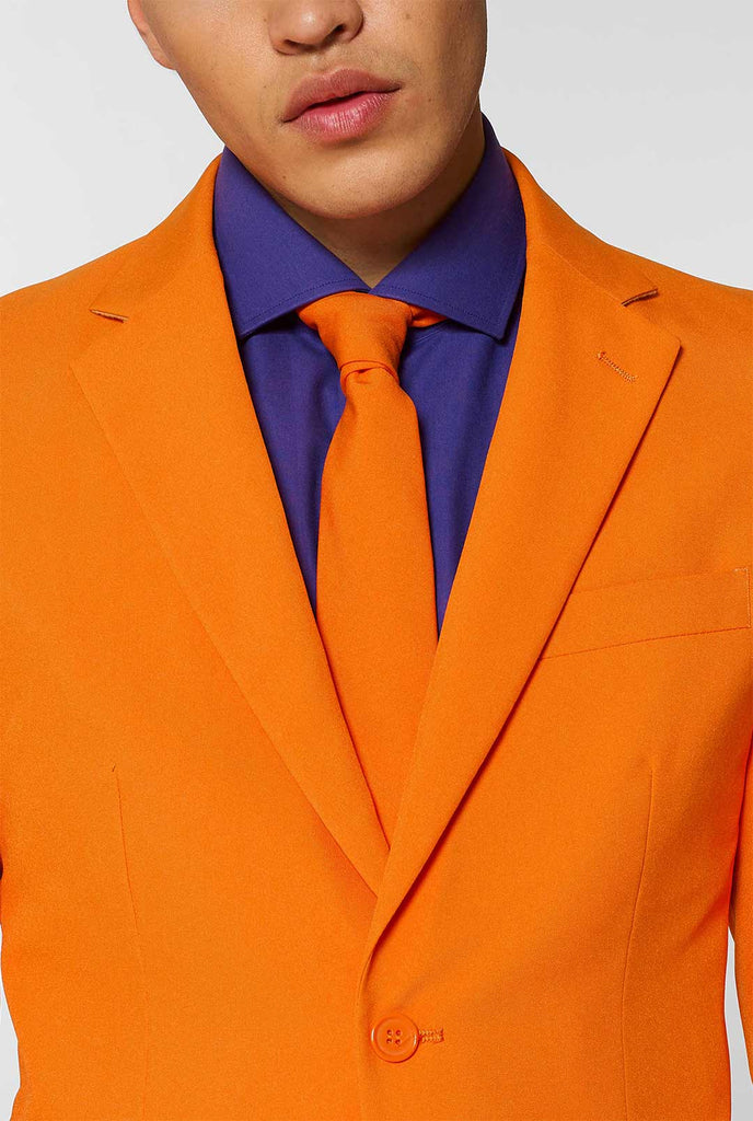 Man wearing orange men's suit with purple dress shirt