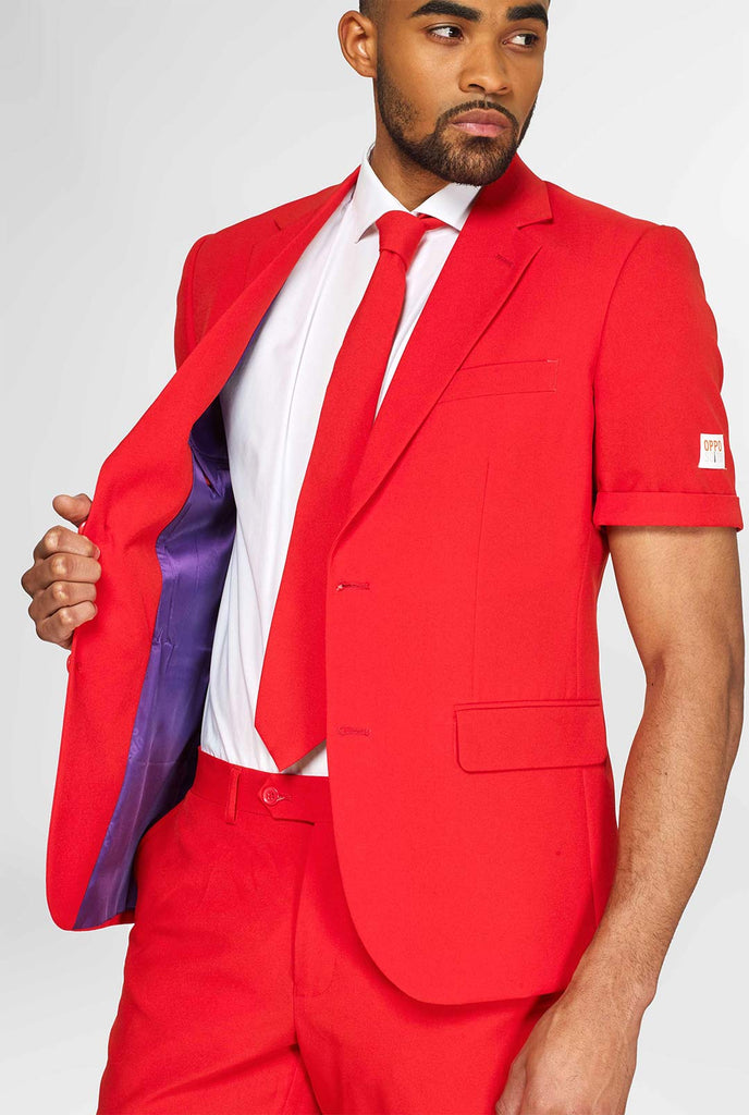 Man wearing red summer suit, consisting of shorts, jacket and tie