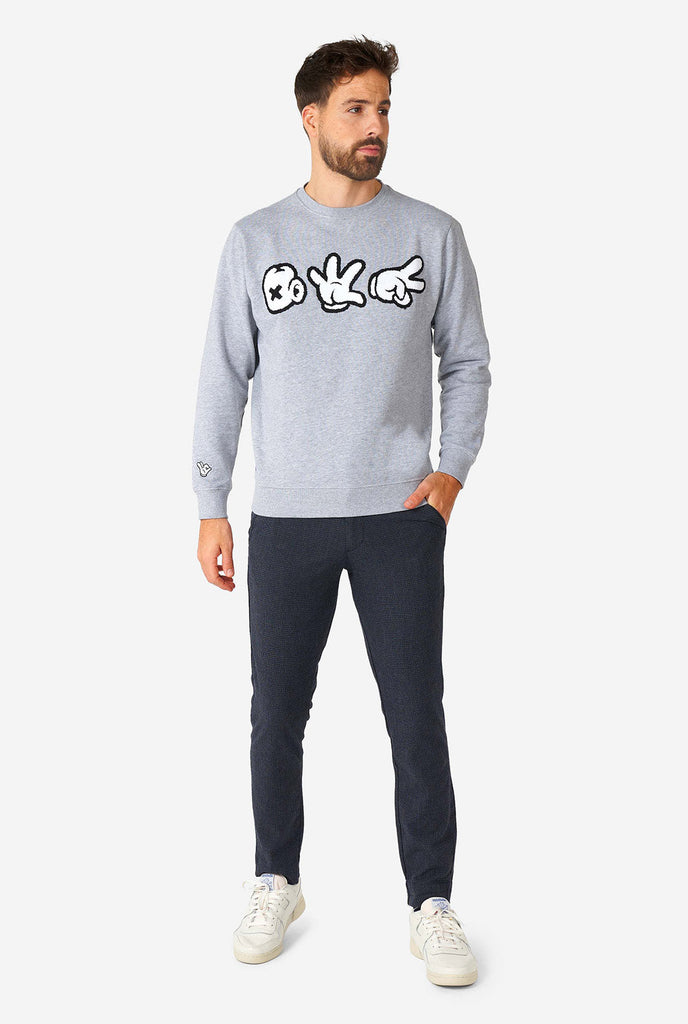 Man wearing grey sweater with chenille rock, paper, scissors embroidery