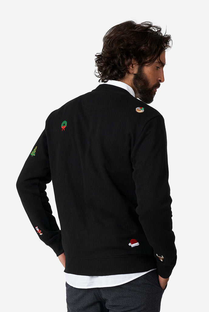 Man wearing black Christmas sweater with Christmas icons