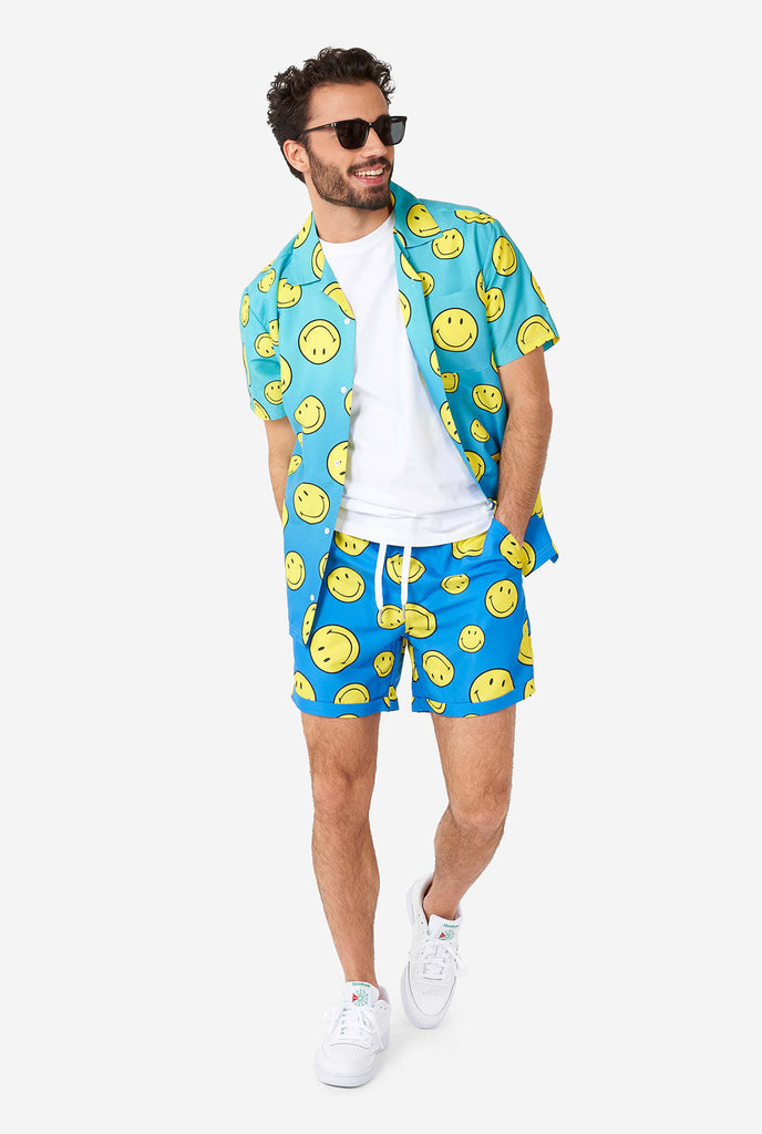 Man wearing blue summer set, consisting of shorts and shirt, with Smiley print