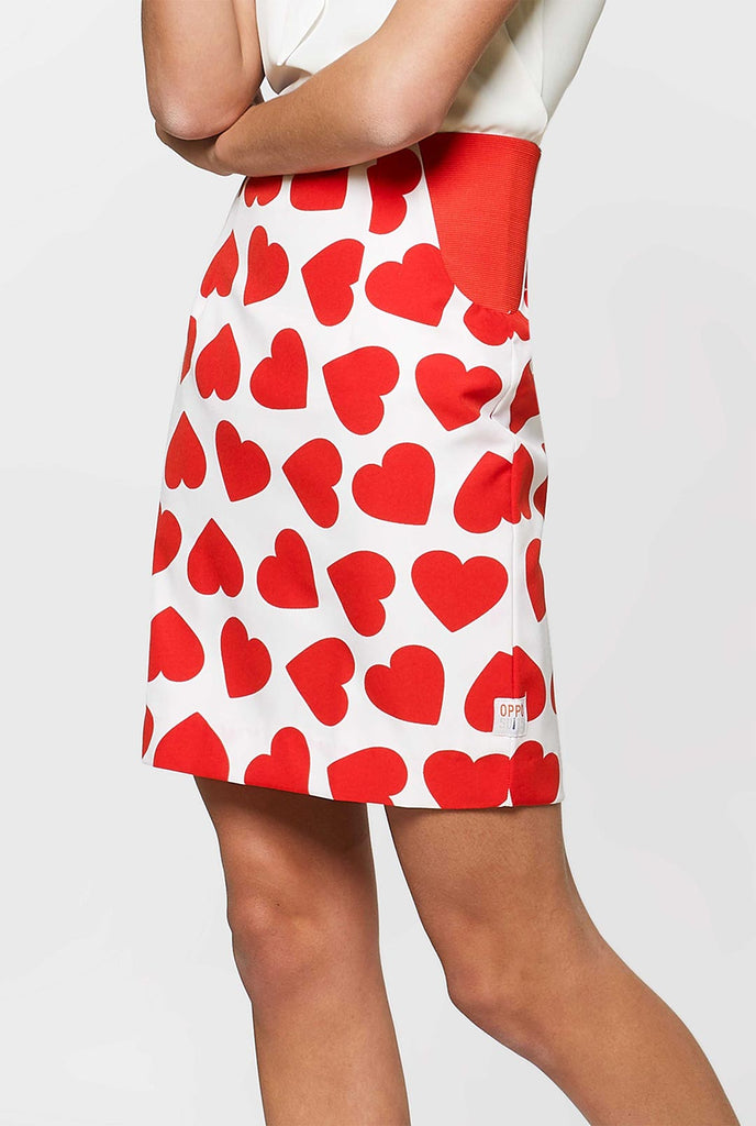 Woman wearing white Valentine's Day suit with red hearts