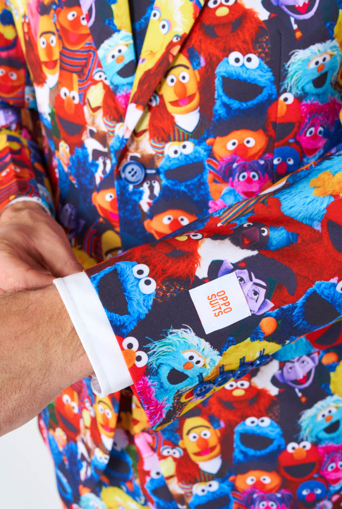 Man wearing men's suit with Sesame street characters print, sleeve close up